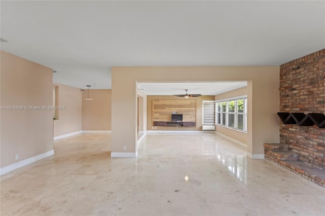 unfurnished living room featuring ceiling fan and a fireplace