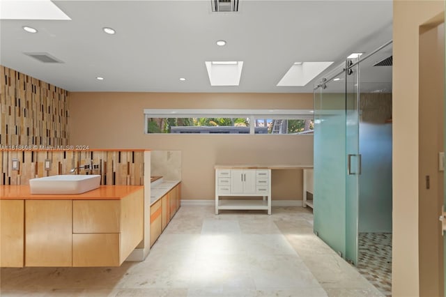 bathroom featuring a shower with door and vanity