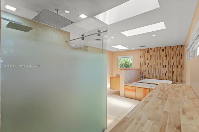 bathroom with a skylight and shower with separate bathtub