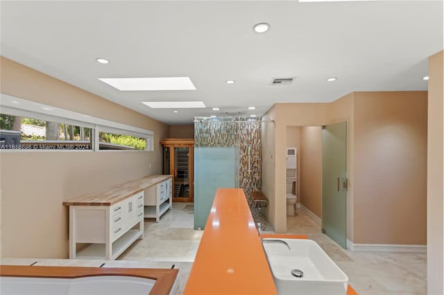 interior space with white cabinetry, butcher block counters, and sink