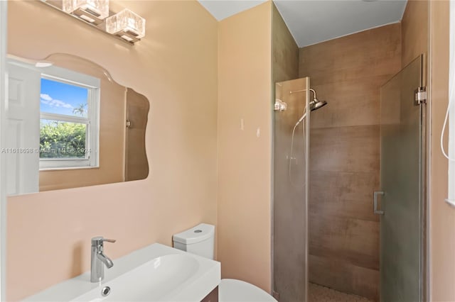 bathroom featuring vanity, a shower with shower door, and toilet