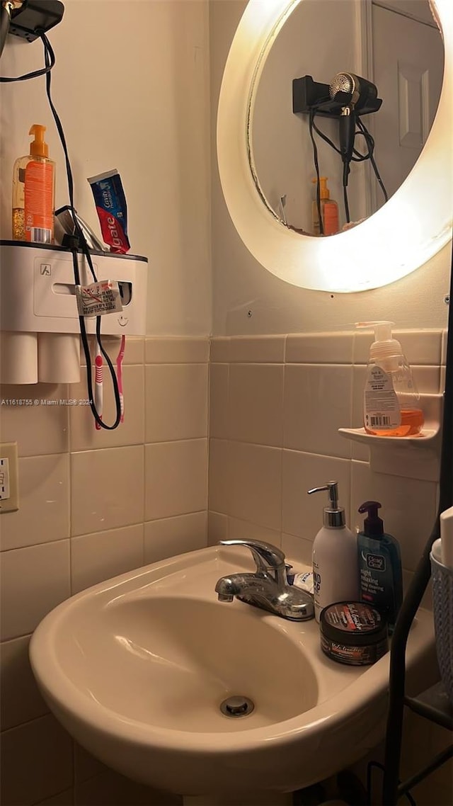 bathroom with sink and tile walls