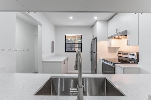 kitchen featuring light stone countertops, sink, stainless steel appliances, and white cabinets