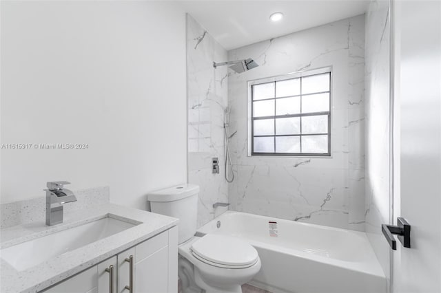 full bathroom featuring tiled shower / bath combo, vanity, and toilet