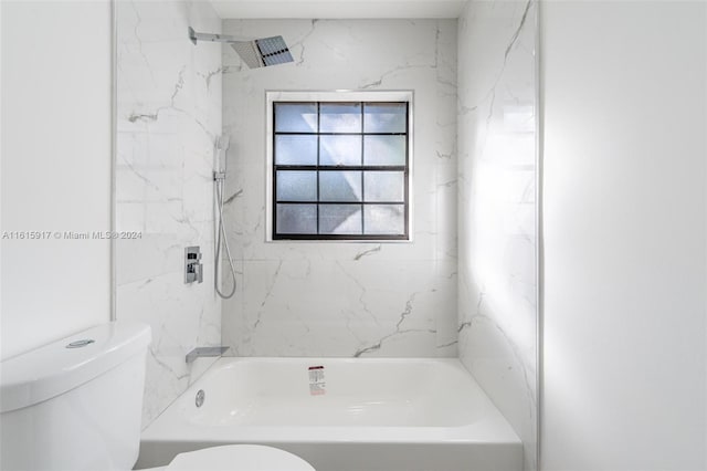 bathroom with tiled shower / bath combo and toilet