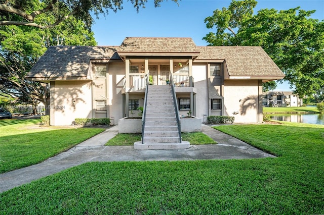 view of front facade with a front lawn and a water view