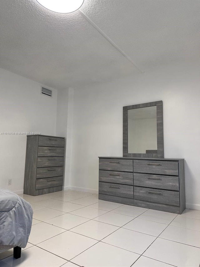 tiled bedroom with a textured ceiling