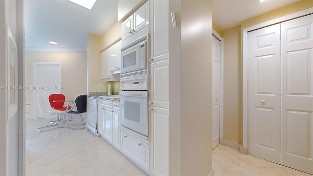 kitchen with white cabinetry, light tile patterned flooring, crown molding, and white appliances