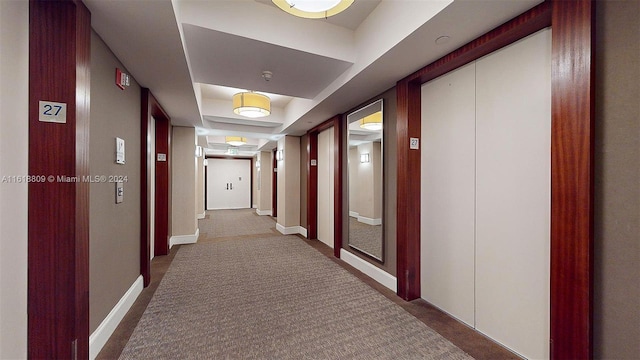 hallway featuring baseboards, carpet flooring, and elevator