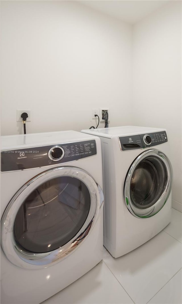 washroom with tile patterned flooring and washing machine and dryer