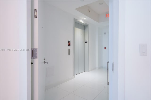 hallway with light tile patterned flooring and elevator