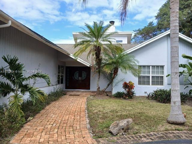 entrance to property featuring a lawn