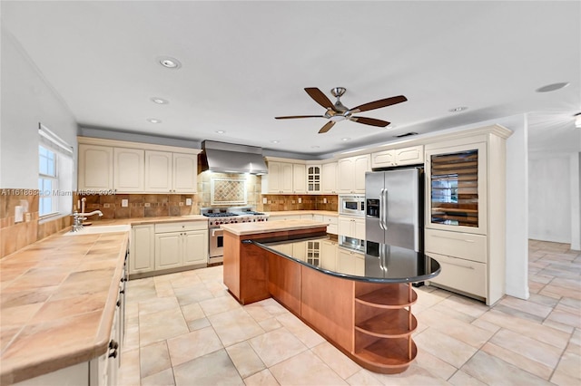 kitchen featuring backsplash, wall chimney exhaust hood, a kitchen island, and stainless steel appliances