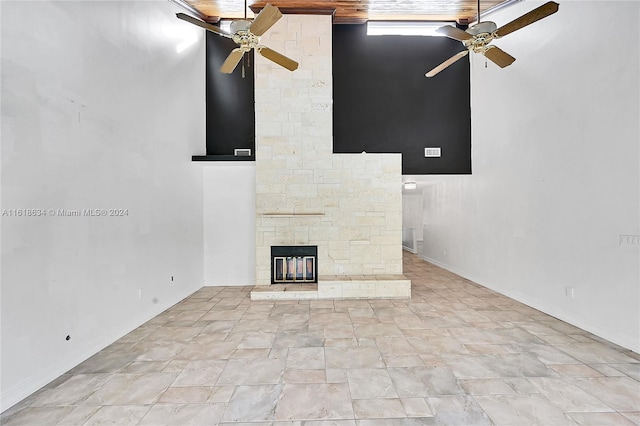 unfurnished living room with ceiling fan and a towering ceiling