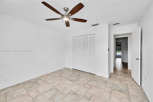 unfurnished bedroom with ceiling fan and a closet