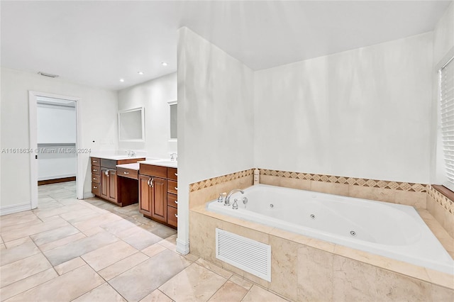 bathroom featuring a relaxing tiled tub and vanity