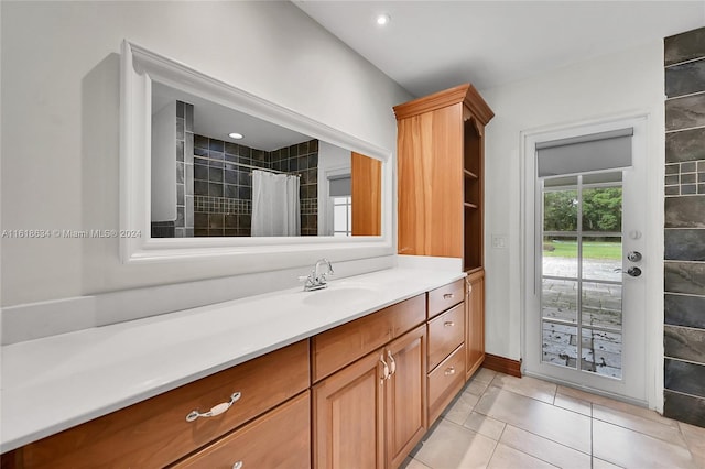 bathroom with tile patterned flooring, vanity, and walk in shower