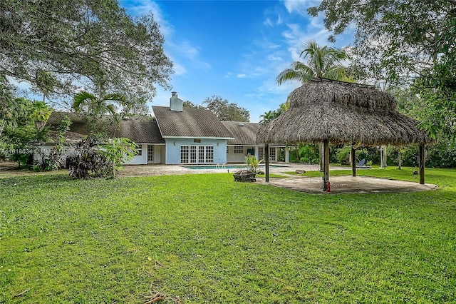 back of property with a gazebo, a patio area, and a yard