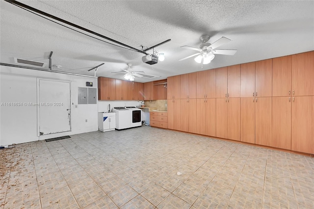 garage featuring independent washer and dryer, electric panel, a garage door opener, and ceiling fan