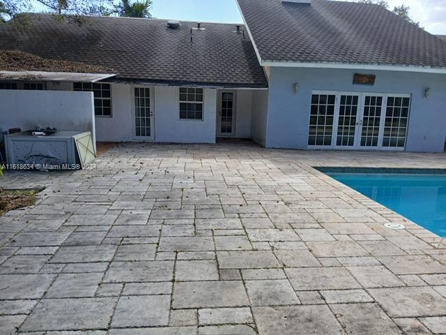 view of swimming pool with french doors and a patio