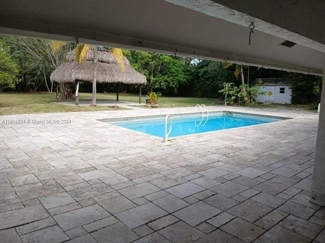 view of swimming pool with a gazebo, an outbuilding, and a patio