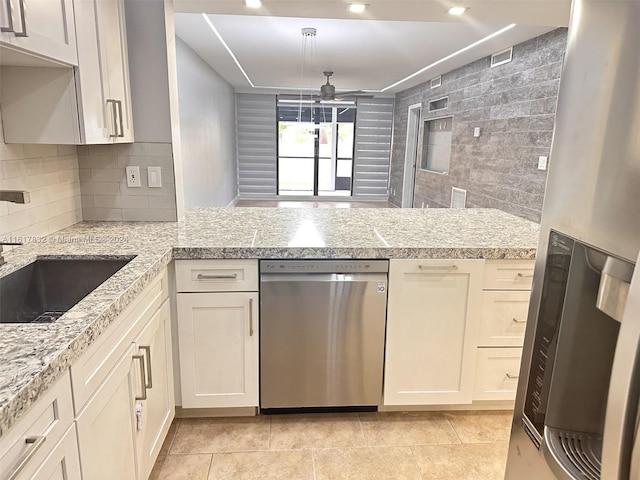 kitchen with appliances with stainless steel finishes, backsplash, ceiling fan, sink, and light tile patterned floors