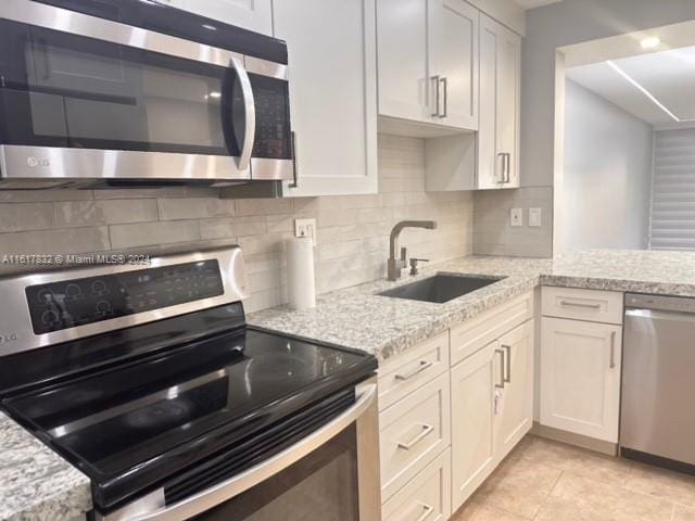 kitchen with sink, white cabinets, and stainless steel appliances