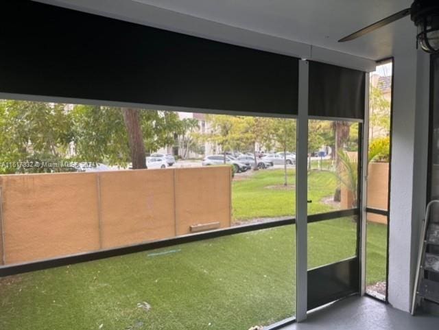 unfurnished sunroom featuring ceiling fan