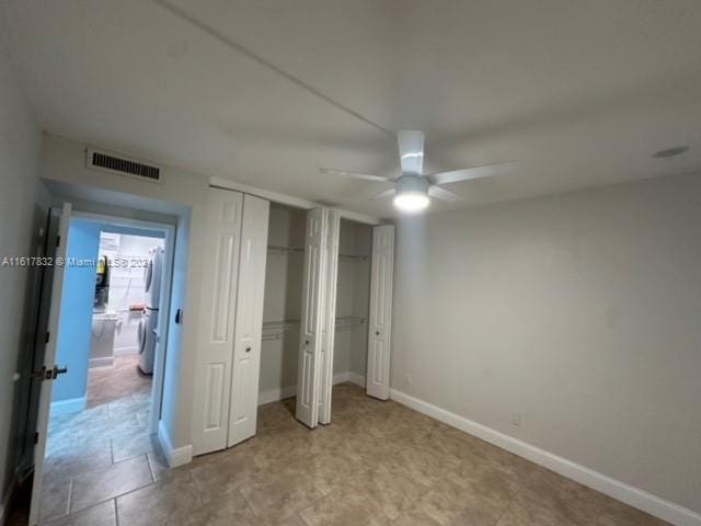 unfurnished bedroom with ceiling fan and multiple closets