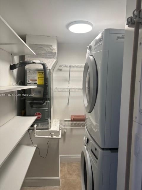 washroom featuring light tile patterned floors and stacked washing maching and dryer