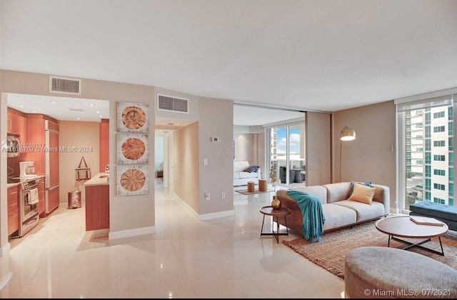 living area featuring a wall of windows, visible vents, and baseboards