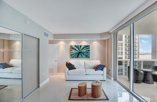 living room featuring a wall of windows and light tile patterned floors