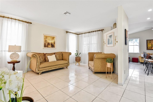 tiled living room with ceiling fan and vaulted ceiling