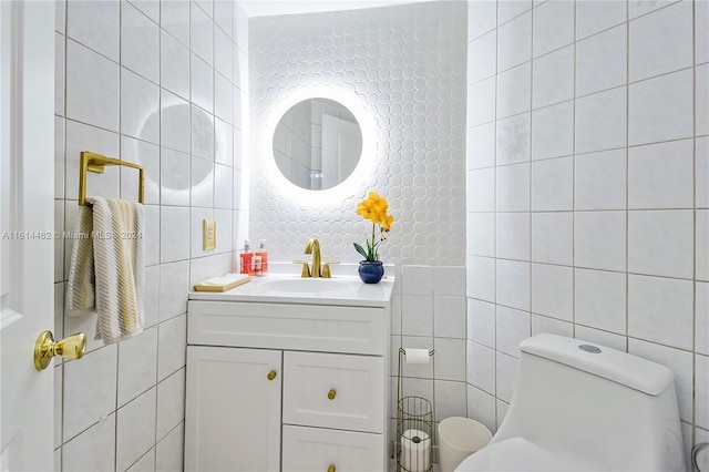 bathroom featuring vanity, toilet, and tile walls