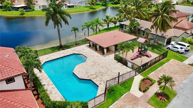 view of pool with a playground, a water view, and a patio area