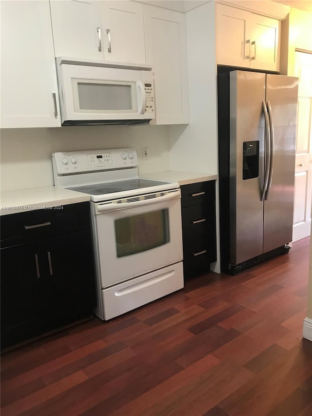 kitchen featuring white cabinetry, dark hardwood / wood-style floors, and white appliances