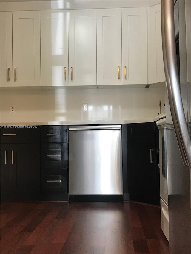 kitchen with appliances with stainless steel finishes, dark hardwood / wood-style floors, and white cabinetry