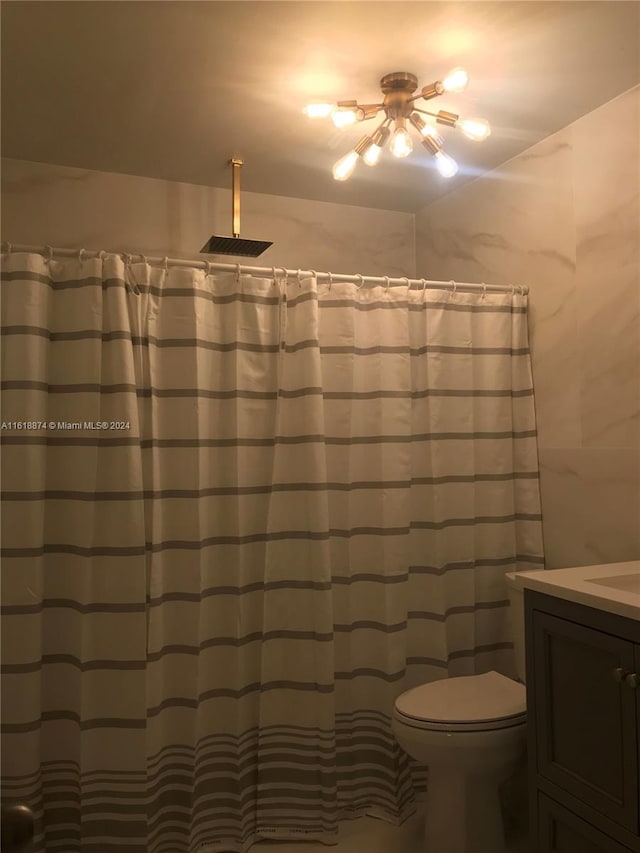 bathroom with toilet, vanity, and ceiling fan