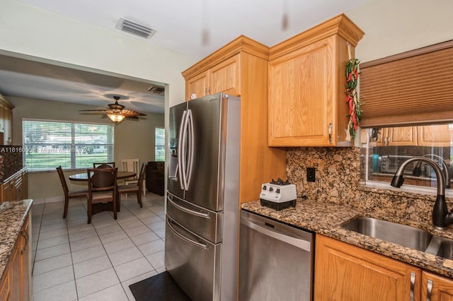 kitchen featuring appliances with stainless steel finishes, sink, decorative backsplash, ceiling fan, and light tile patterned flooring