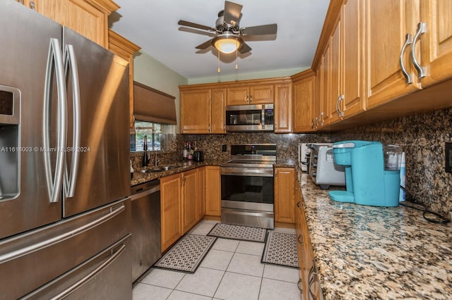 kitchen with tasteful backsplash, light tile patterned floors, sink, ceiling fan, and appliances with stainless steel finishes