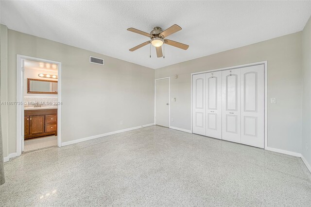 unfurnished bedroom with ensuite bath, sink, a textured ceiling, and ceiling fan