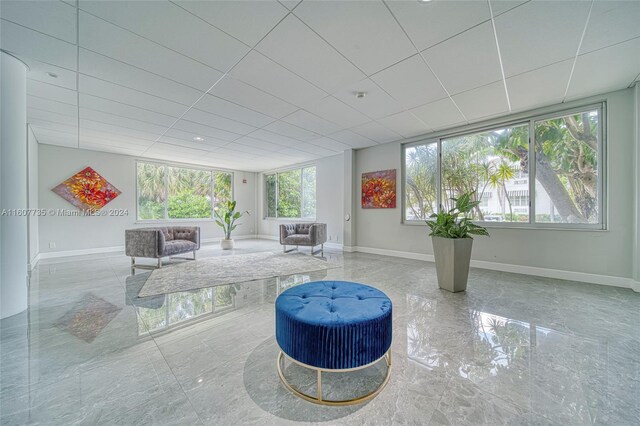 living room with a drop ceiling and tile patterned floors