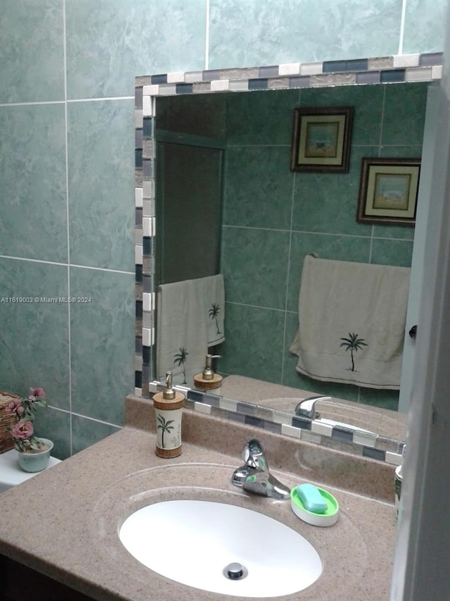 bathroom featuring vanity and tile walls