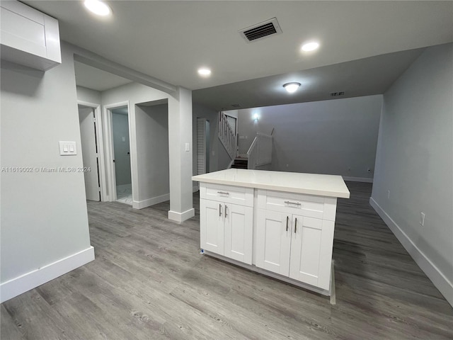 kitchen featuring white cabinetry, wood-type flooring, and a kitchen island