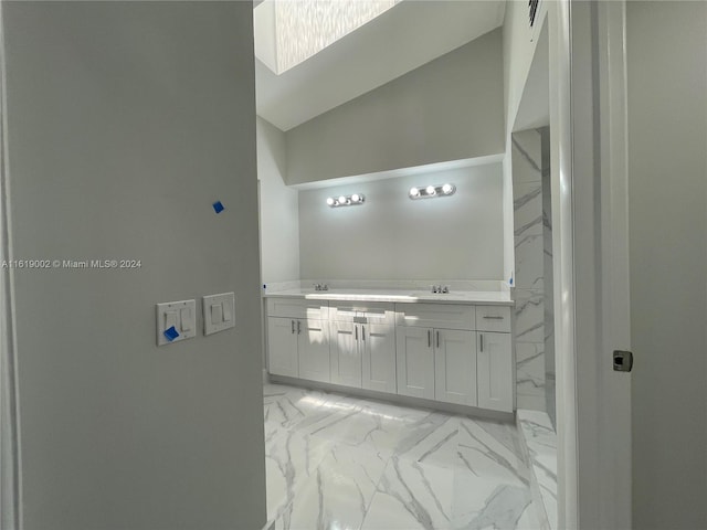 bathroom with tile patterned floors, vanity, and high vaulted ceiling