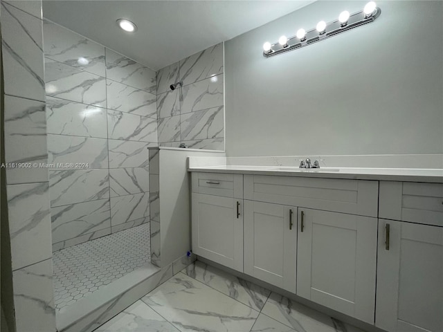 bathroom featuring vanity, tiled shower, and tile patterned flooring