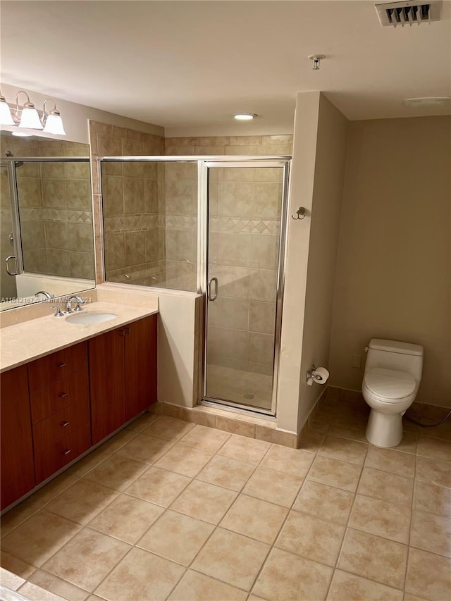 bathroom featuring tile patterned flooring, vanity, toilet, and an enclosed shower