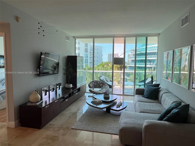 living room with a wealth of natural light, expansive windows, and ceiling fan