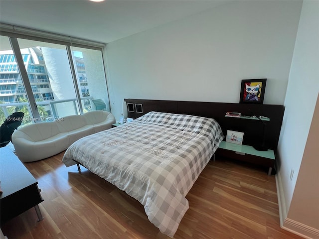 bedroom featuring expansive windows and wood-type flooring