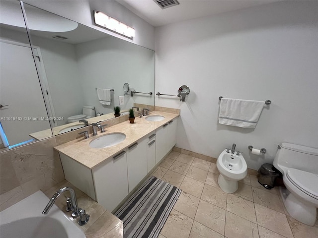 bathroom featuring vanity, a bidet, a bath, and toilet